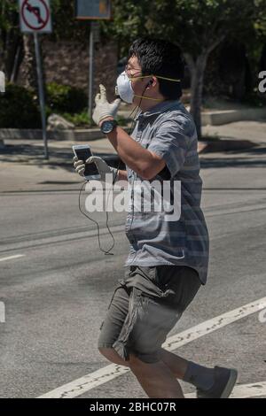 Los Angeles, Kalifornien, USA. April 2020. Ein Mann tanzt am Freitag, den 24. April, über einen Fußgängerweg, während er unter COVID-19-Beschränkungen in Los Angeles, Kalifornien, durch den Alltag geht. Foto von Justin L. Stewart Quelle: Justin L. Stewart/ZUMA Wire/Alamy Live News Stockfoto