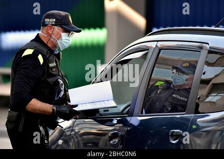 Vendrell, Spanien. April 2020. Ein Polizist gibt einem Fahrer eine Strafe, weil er die Haftbedingungen nicht eingehalten hat.Lokale Polizisten werden auf den Straßen von El Vendrell eingesetzt, um ungerechtfertigte Bewegungen von Bürgern aus anderen Städten zu patrouillieren und zu kontrollieren, die an einem Wochenende und bis zu ihren Zweitwohnungen gelangen Stellen Sie sicher, dass die Regeln für die Beschränkung eingehalten werden, um die Ausbreitung des COVID-19 Coronavirus zu kontrollieren. Quelle: SOPA Images Limited/Alamy Live News Stockfoto