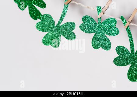 Happy St. Patricks Day Hintergrund. Grüner Glitzer schamrockt hausgemachte Girlande, kopieren Raum. Stockfoto