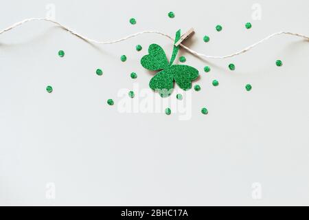 St. Patricks Tag Hintergrund mit hausgemachten Glitter Schamlippen Girlande. Glänzendes Papier geschnitten Kleeblatt auf Wäscheklammer. Stockfoto