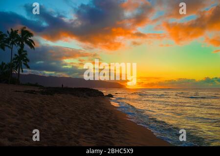 Dramatischer Sonnenuntergang über dem Meer am leeren Strand in Haleiwa, Hawaii Stockfoto