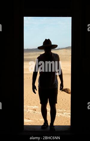 Person im Eingang des verlassenen Hauses, Kolmanskop Geisterstadt, in der Nähe von Luderitz, Namibia, Afrika Stockfoto