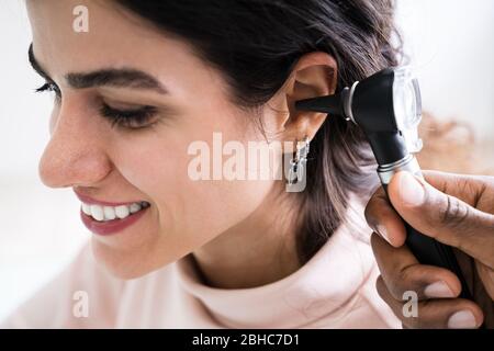 Nahaufnahme des Ohr weiblichen der Arzt, der die Untersuchung Patienten mit Otoskop Stockfoto