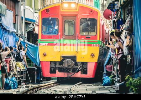 Samut Songkhram. Thailand. 23. Juli 2019: Die Eisenbahn wurde berühmt für ihre Strecke durch den Maeklong Eisenbahnmarkt. Wenn sich ein Zug nähert, aw Stockfoto