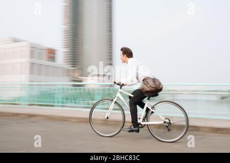 Verschwommenes Bild von Asiaten, die auf dem Fahrrad unterwegs sind, in der Stadt mit Geschwindigkeit und hipperstem, trendigen Transport Stockfoto