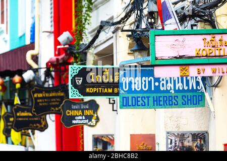 Phuket, Districtul Mueang Phuket, Thailand. 3. August 2019: Geschäftsschilder entlang einer Straße in der Altstadt von Phuket in Thailand. Zahlreiche Farbfu Stockfoto