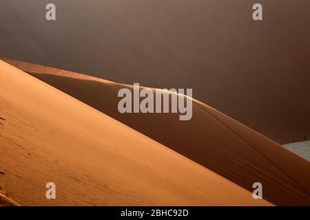 Menschen klettern Sanddünen neben Deadvlei, in der Nähe von Sossusvlei, Namib-Naukluft National Park, Namibia, Afrika Stockfoto
