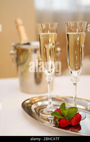 Foto von zwei Gläsern Champagner und Erdbeeren auf Teller mit einer Flasche Champagner Stockfoto