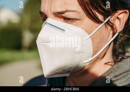 LUXEMBURG/APRIL 2020: Frau, die eine schützende KN95-Maske gegen COVID-19 trägt Stockfoto