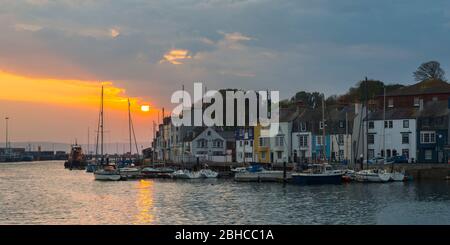 Weymouth, Dorset, Großbritannien. April 2020. Wetter in Großbritannien. Ein dramatischer Himmel bei Sonnenaufgang am Hafen von Weymouth in Dorset. Bild: Graham Hunt/Alamy Live News Stockfoto