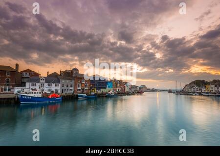 Weymouth, Dorset, Großbritannien. April 2020. Wetter in Großbritannien. Ein dramatischer Himmel bei Sonnenaufgang am Hafen von Weymouth in Dorset. Bild: Graham Hunt/Alamy Live News Stockfoto