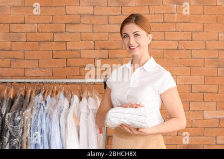 Arbeiter der modernen Trockenreiniger auf Backstein Hintergrund Stockfoto