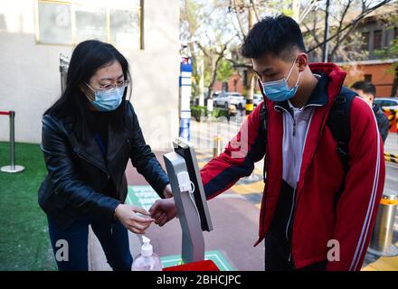 Taiyuan, Chinas Provinz Shanxi. April 2020. Ein Schüler erhält eine Körpertemperatur, bevor er den Campus in einer Mittelschule in Taiyuan, Nordchinesische Provinz Shanxi, am 25. April 2020 betritt. Die Schüler in ihrem letzten Jahr der Junior High School kehrten am Samstag in die Schule in Taiyuan zurück. Kredit: Chai Ting/Xinhua/Alamy Live News Stockfoto