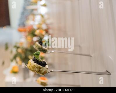 Leckere Häppchen in Reihe mit Kaviar und Frischkäse Vorspeisen, isoliert auf weißem Hintergrund Blick, Finger Food Snacks während des Hotel Brunch Stockfoto