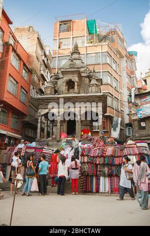 KATHMANDU, NEPAL - 29. SEPTEMBER 2012: Auf den Stufen eines antiken Tempels werden Pashmina-, Kaschmir- und Yakwolle-Textilien verkauft Stockfoto