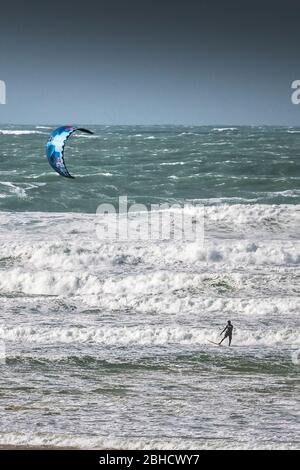 Ein einsamer Kitesurfer, der den starken Wind von Storm Jorge in Fistral in Newquay in Cornwall genießt. Stockfoto