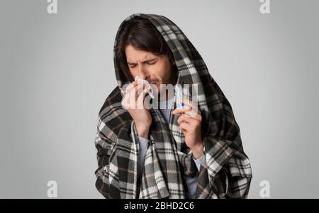 Kranker Mann mit Serviette und Tropfen für Nase in den Händen Stockfoto