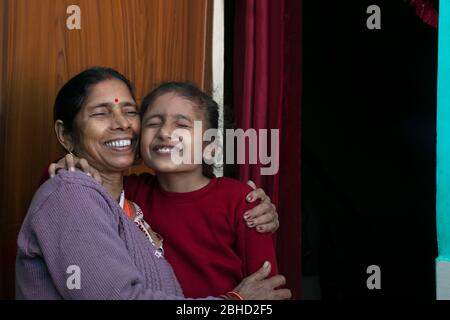 Glückliche Großmutter und Enkelin umarmen einander, Indien Stockfoto