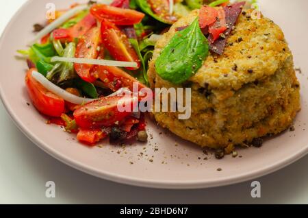Geräucherter Schellfisch-Fischkuchen mit schmelzender Cheddar-Sauce und gemischtem Salat, Fisch und Meeresfrüchte Stockfoto