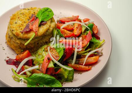 Geräucherter Schellfisch-Fischkuchen mit schmelzender Cheddar-Sauce und gemischtem Salat, Fisch und Meeresfrüchte Stockfoto