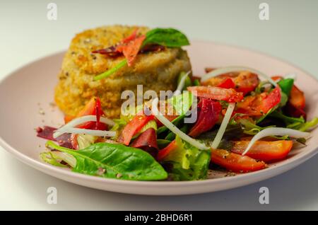 Geräucherter Schellfisch-Fischkuchen mit schmelzender Cheddar-Sauce und gemischtem Salat, Fisch und Meeresfrüchte Stockfoto