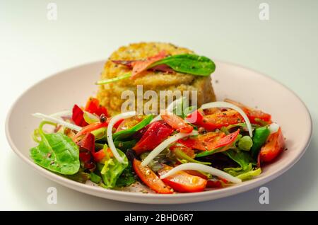 Geräucherter Schellfisch-Fischkuchen mit schmelzender Cheddar-Sauce und gemischtem Salat, Fisch und Meeresfrüchte Stockfoto
