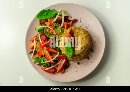 Geräucherter Schellfisch-Fischkuchen mit schmelzender Cheddar-Sauce und gemischtem Salat, Fisch und Meeresfrüchte Stockfoto