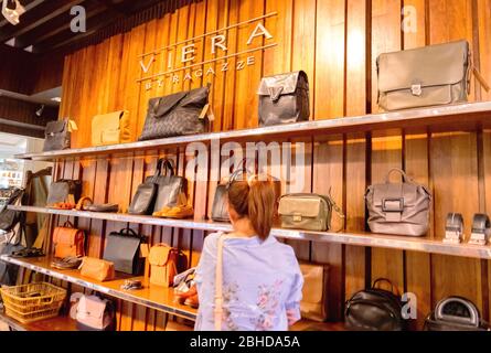 Die EINE Frau, die Ledertasche in Viera wählt Ledertasche Laden in Dorf Markt Einkaufszentrum Hua hin, Thailand 12. Januar 2019 Stockfoto