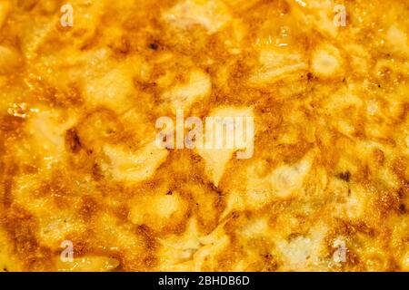 Hintergrund einer appetitlichen spanischen Tortilla. Textur und Details eines Omeletts mit Eiern, Kartoffeln und Zwiebeln. Stockfoto