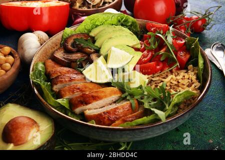 Gesunde Salatschüssel mit Quinoa, Tomaten, Huhn, Avocado, Limette und gemischtem Gemüse, Salat. Essen und Gesundheit. Stockfoto