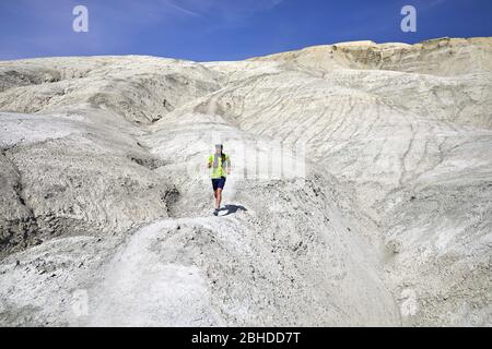 Runner Athlet mit Bart, der auf dem Trail in White Clay Berge in der Wüste Stockfoto