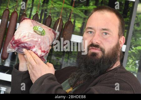 Greifswald, Deutschland. April 2020. Torsten klar, Leiter der Firma Wildbet MV KG, verkauft Wildfleisch auf dem Greifswalder Wochenmarkt. Die Spielhändler kaufen bundesweit kaum etwas. Entweder sind ihre Kühlhäuser voll oder es fehlt ihnen das Geld, um die Jäger für das Spiel zu bezahlen. Restaurants waren bisher die Hauptkunden der Game Traders. (Zu dpa 'Jäger können sich nicht loswerden - Restaurants waren die Hauptkunden') Quelle: Stefan Sauer/dpa-Zentralbild/dpa/Alamy Live News Stockfoto