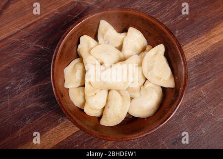 Vareniki mit Käse sind ukrainische Lebensmittel auf einem Holzhintergrund. Pasteten mit Kartoffeln und Käse Stockfoto