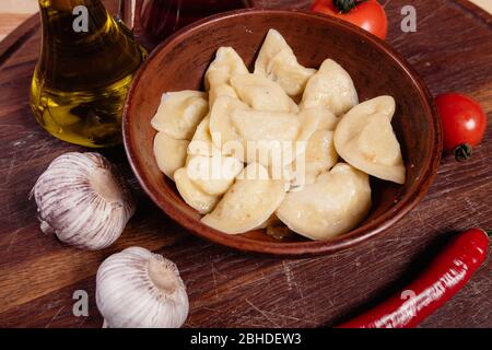 Vareniki mit Käse sind ukrainische Lebensmittel auf einem Holzhintergrund. Pasteten mit Kartoffeln und Käse Stockfoto