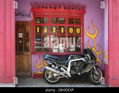 Großes Motorrad vor Tribal Urge Tattoo Salon, Castle Road, Southsea, Portsmouth, England, UK geparkt Stockfoto