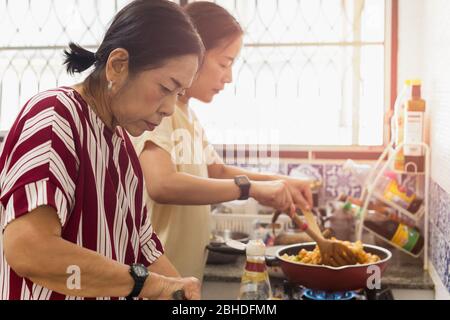 Asiatische Frau in der Küche Kochen Essen während der Quarantäne. Stockfoto