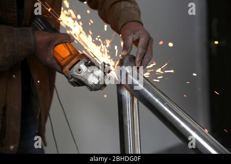Elektrische Schleifscheiben auf Stahlkonstruktion im Baubereich Stockfoto