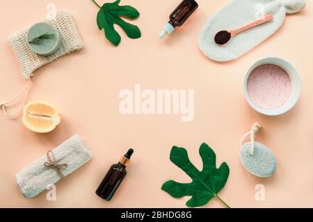Herstellung von natürlichen Hautpflegeprodukten zu Hause. Zutaten für Gesichtsmaske, rosa Salz, Zitrusfrüchte, gemahlenen Kaffee, ätherische Öle und Toilettenartikel auf orangefarbenem Backg Stockfoto