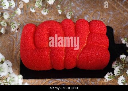 Roter Love Word Mousse Kuchen, Blick von oben, ideales süßes Geschenk für Muttertag, Valentinstag, Frauentag, Happy Birthday Konzept. Stockfoto