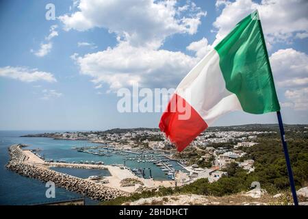 Die italienische Flagge in den Farben Grün-Weiss-Rot wht über der Stadt Santa Maria di Leuca in Apulien in Süd-Italien. The Kaps is is be the the Stockfoto
