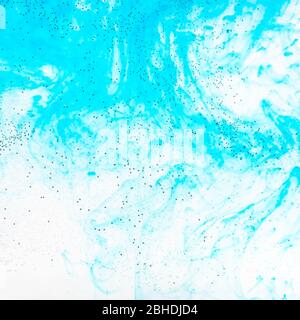 Luftblasen auf der Glasoberfläche der flachen Flasche und aquamarinfarbenen Aquarelle fließen im Wasser auf dem Hintergrund Stockfoto