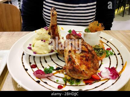 Foto von Schweinefleisch Steak mit seiner Soße und Kohl auf dem weißen Teller Stockfoto