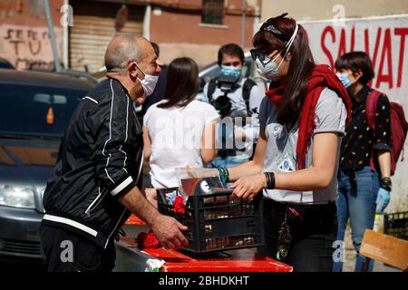 Roma, Italien. April 2020. Rom, 25. April 2020. Coronavirus-Sperrung. In ganz Italien hat die Sperrung des Coronavirus die Wirtschaftskrise verbessert, so dass in vielen Nachbarschaften Vereine und Freiwillige Essen an weniger wohlhabende Menschen verteilen. Am 25. April (Jahrestag der Befreiung Italiens vom nazi-Faschismus und Jahrestag des Widerstands) verteilen Freiwillige des Roten Labors zusammen mit Lebensmitteln, einer roten Nelke und einem Foto. Foto Samantha Zucchi Insidefoto Quelle: Insidefoto srl/Alamy Live News Stockfoto