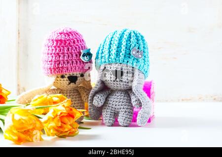 Handgemachte Häkelkaninchen Spielzeug auf grünem Hintergrund. Amigurumi Puppe. Selektiver Fokus Stockfoto