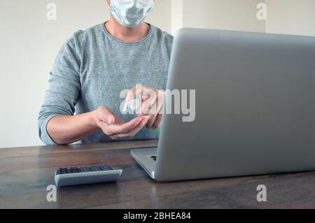 Eine Person, die während einer Epidemie zu Hause auf einem Laptop arbeitet Stockfoto