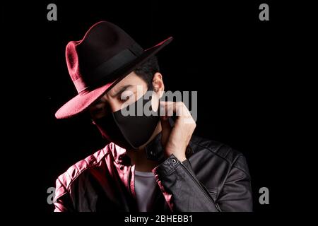 Mann, der in einer schwarzen Gesichtsmaske wegschaut Stockfoto