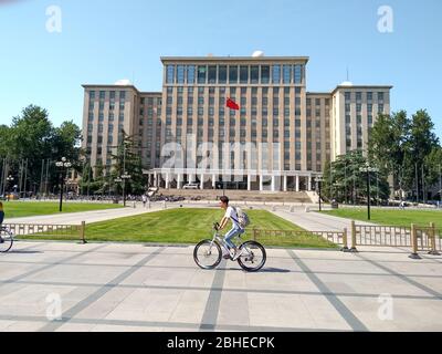 Peking, China, 1. Juni 2018: Studenten fahren vor dem Haupteingang des berühmten Tsinghua Universitätsgebäudes in Peking Stockfoto