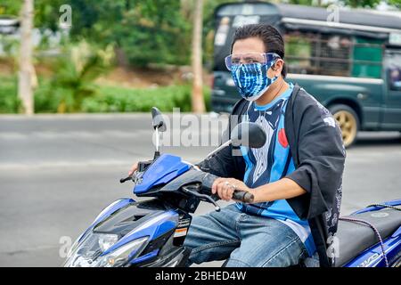 Ein Mann auf einem Motorrad mit einer Gesichtsmaske. Stockfoto