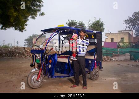 Indischer E Rikscha-Fahrer mit seinem Kind, Indien Stockfoto