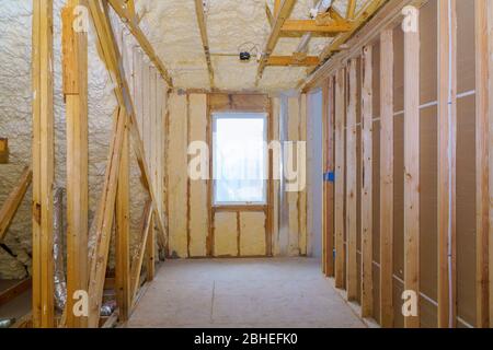 Neues Holzhaus in Schaum für die Isolierung der Wand des Dachbodens mit unvollendeten im Bau Stockfoto